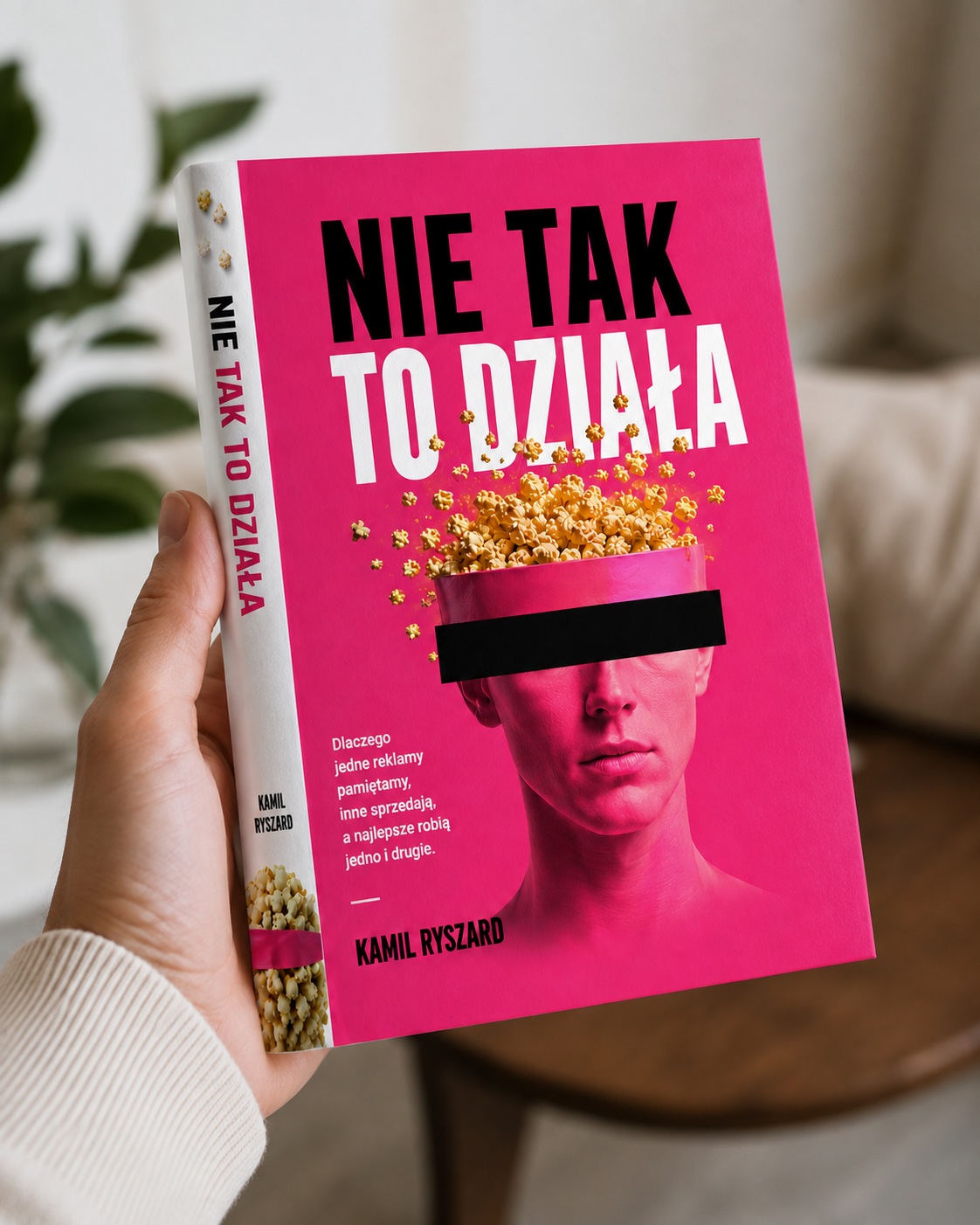 Wizualizacja książki „Nie tak to działa” trzymanej w dłoni